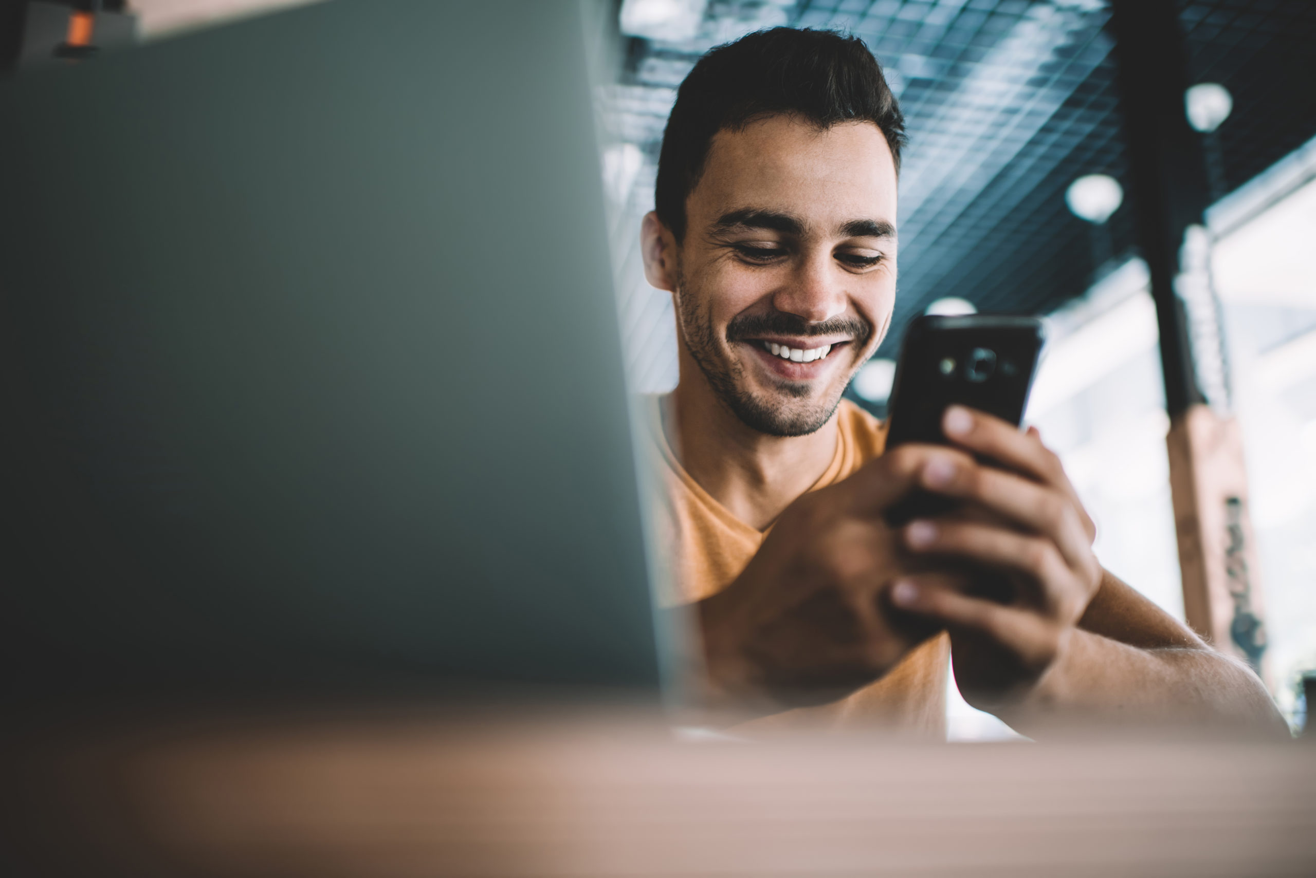 Jeune homme souriant téléphone portable smartphone newsletter information